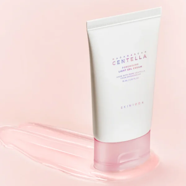 Madagascar Centella Poremizing Light Gel Cream1.webp : Crème en gel Skin1004 Madagascar Centella posée sur un fond rose avec texture étalée, idéale pour hydrater et affiner le grain de peau.